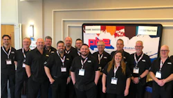 PBE Distributors team photo with employees in matching black uniforms at corporate event