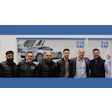 PPG team photo with six professionals and silver sports car display