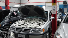 Cash-filled Toyota engine compartment in automotive repair shop