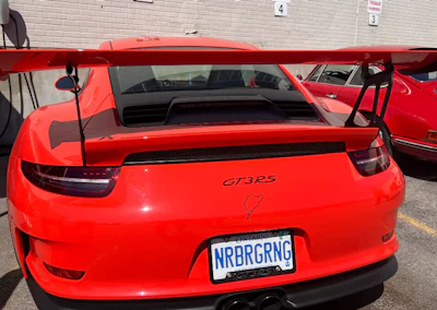 Red Porsche GT3 RS with racing wing in parking lot