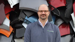 Professional in Plasnomic sweater against fragmented automotive panel background