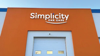 Simplicity Car Care facility with orange exterior and blue garage door