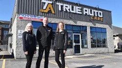 True Auto Care team of three staff members posing outside their repair shop