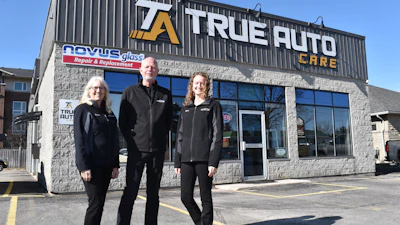 True Auto Care team of three staff members posing outside their repair shop