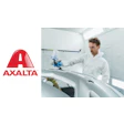 Technician applying automotive paint using spray equipment in professional refinishing workshop