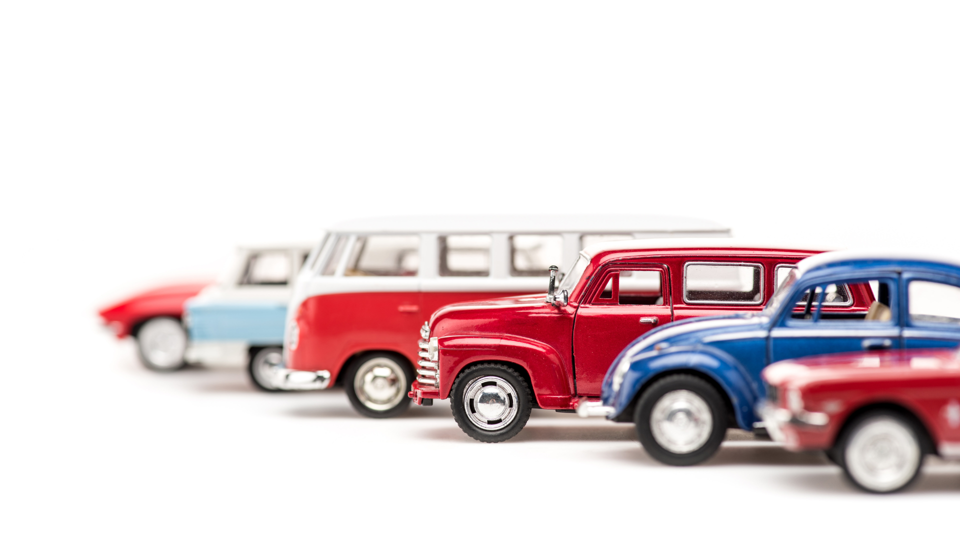 Vintage toy cars lineup featuring classic vehicles in red, blue, and white
