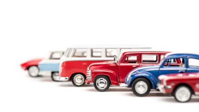 Vintage toy cars lineup featuring classic vehicles in red, blue, and white