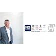 FIX Network executive in gray suit with automotive service brands display