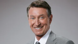 Smiling professional in gray suit with warm, confident expression