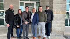 Mercedes-Benz team receiving achievement award outside corporate building