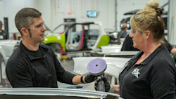 Automotive technicians working together with polishing equipment in repair shop
