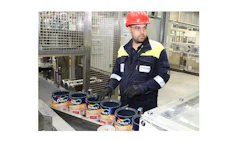 Factory worker monitoring Dulux paint can production line with safety equipment
