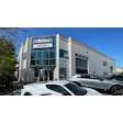 Preston Collision auto repair shop with white building and parked vehicles