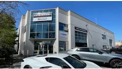 Preston Collision auto repair shop with white building and parked vehicles