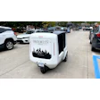 Brooklyn Pizza autonomous delivery vehicle with city skyline graphic in urban parking lot