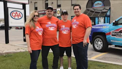 Dante's Car Wash team in orange shirts posing outside local business location