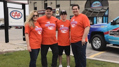 Dante's Car Wash team in orange shirts posing outside local business location