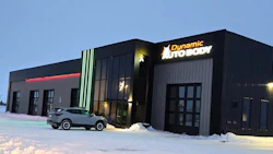 Dynamic Auto Body shop exterior with illuminated signage, gray SUV, winter snow scene