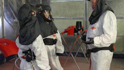 Hazmat workers in protective gear during safety training exercise