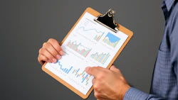 Financial data analysis clipboard with colorful bar graphs and trend lines