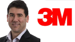 Smiling professional in business attire beside 3M corporate logo