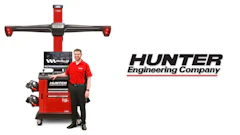 Hunter wheel alignment machine with technician demonstrating automotive diagnostic equipment