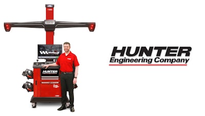 Hunter wheel alignment machine with technician demonstrating automotive diagnostic equipment