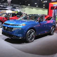 Blue Nissan SUV on display at automotive exhibition with modern design