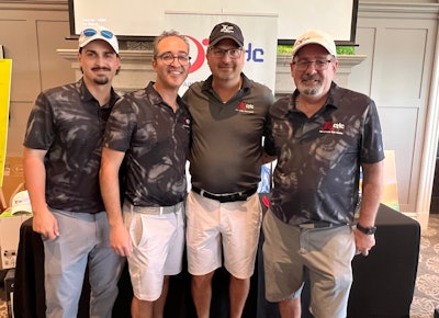 XGC team of four professionals posing together at corporate event