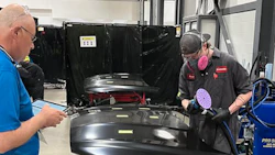 Auto technicians repairing vehicle component in professional workshop