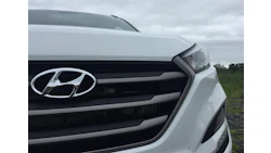 White Hyundai vehicle front grille with chrome logo on cloudy day
