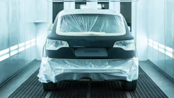 Vehicle prepared for painting in automotive spray booth with protective plastic covering