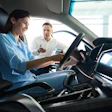 Car salesperson showing vehicle interior to potential customer