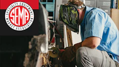 Skilled technician grinding metal with sparks, wearing safety gear in workshop