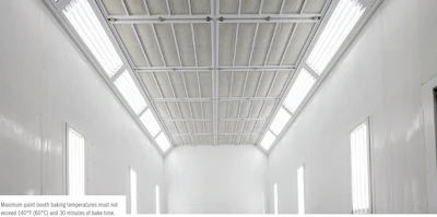 White industrial paint booth with metal ceiling and vertical light panels