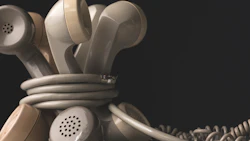 Tangled vintage telephone handsets in neutral tones, twisted together