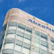 AkzoNobel corporate headquarters with curved glass and metal exterior against blue sky