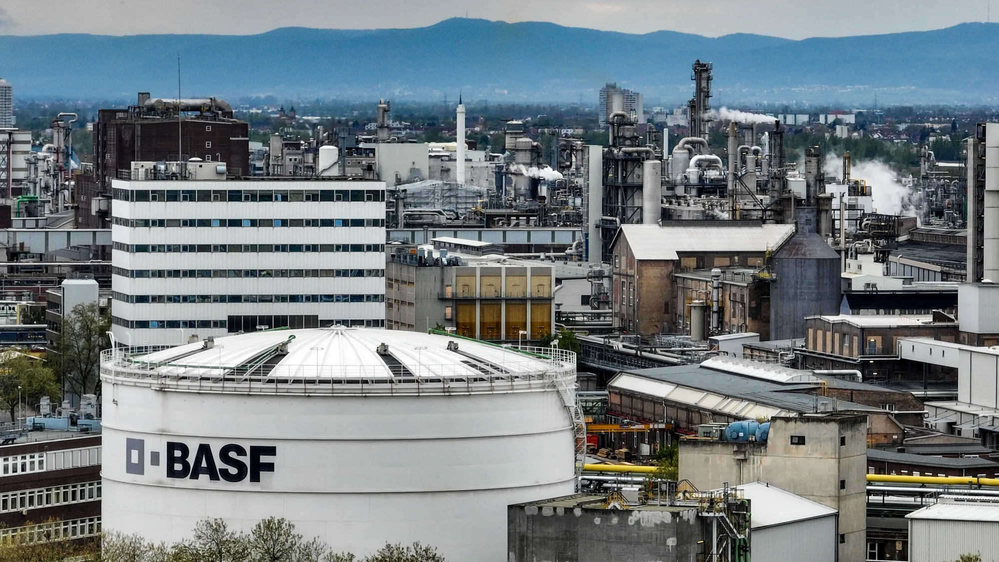 BASF chemical manufacturing facility with industrial buildings and mountains in background