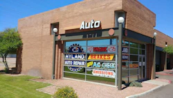 Brick auto repair shop storefront with service signs in window