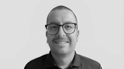 Smiling professional in black shirt and glasses, black and white portrait