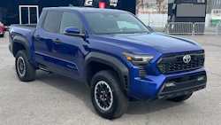 Blue Toyota pickup truck with black trim parked at racing facility