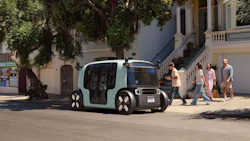Autonomous mint green vehicle parked on urban street with pedestrians nearby