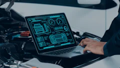 Laptop displaying digital automotive diagnostic interface on vehicle dashboard