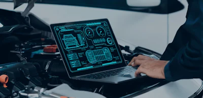 Laptop displaying digital automotive diagnostic interface on vehicle dashboard
