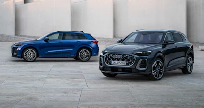 Two Audi SUVs - blue and black - parked on a concrete surface