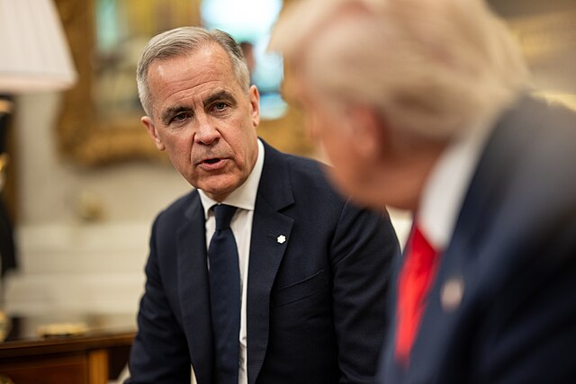 Two professionals in formal attire conversing in an official setting