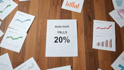 Wooden floor with scattered data charts showing 20% fall in auto theft statistics