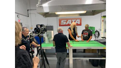 SATA logo on wall during industrial video production with green work table