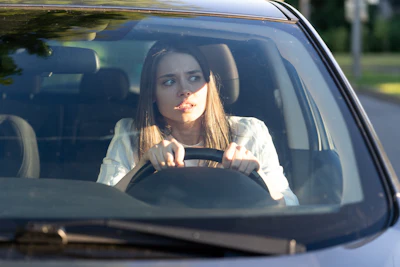 Young driver looking focused while gripping steering wheel in car