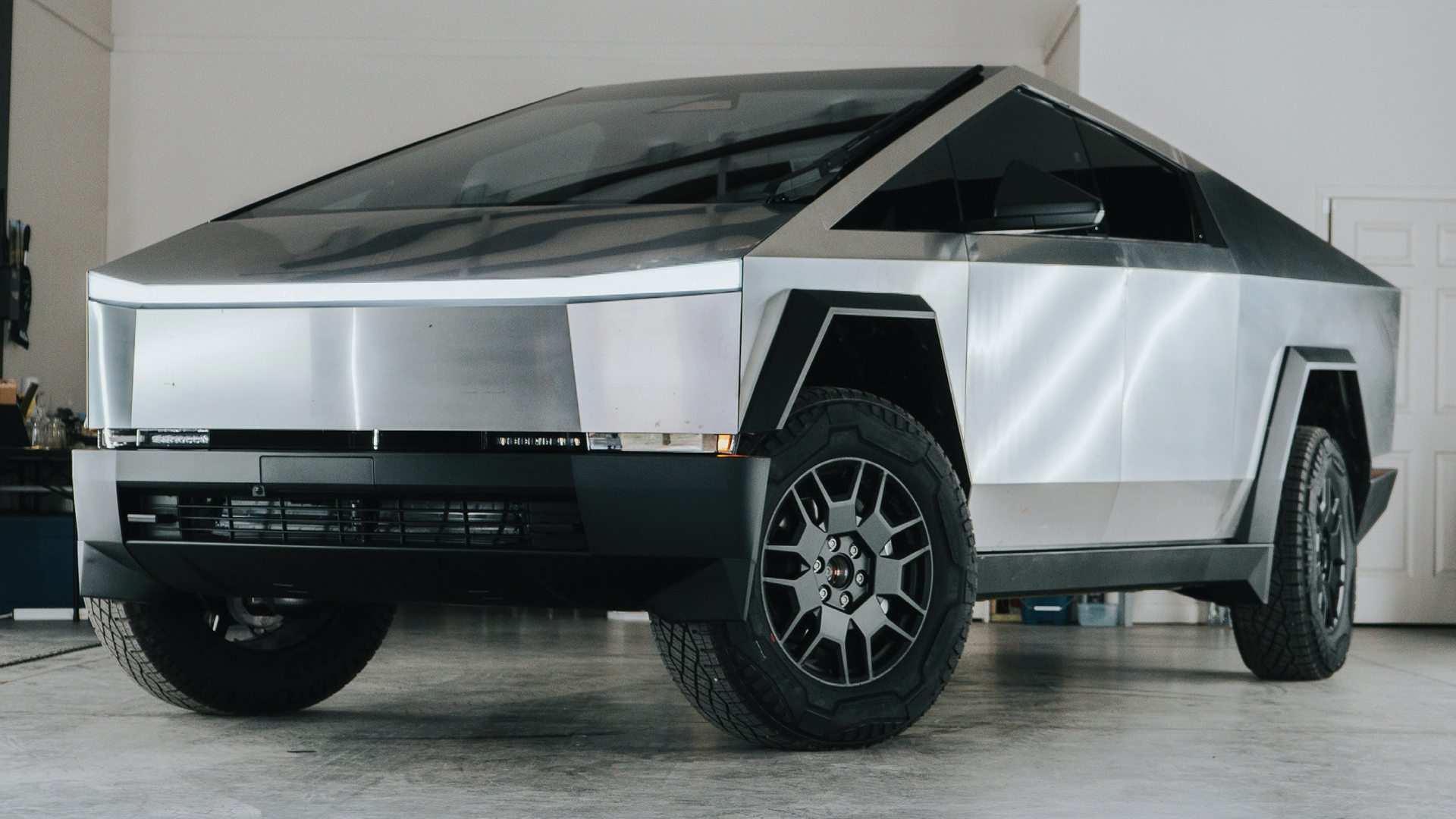 Silver Tesla Cybertruck with angular design parked in minimalist interior